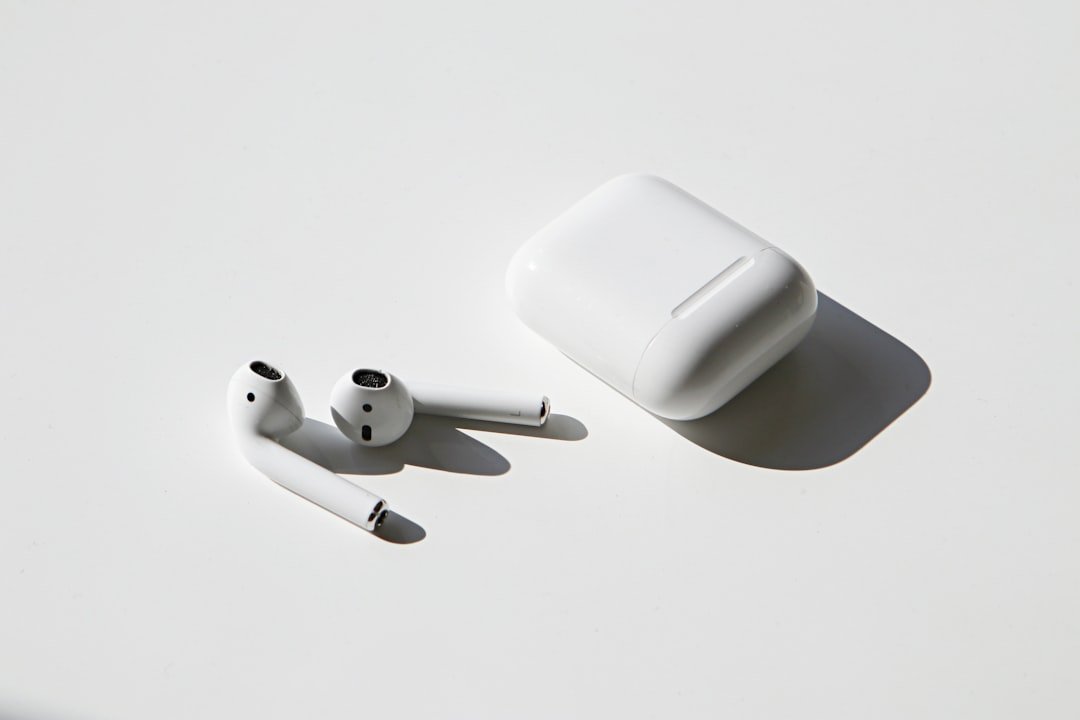 Apple AirPods with charging case on a white table