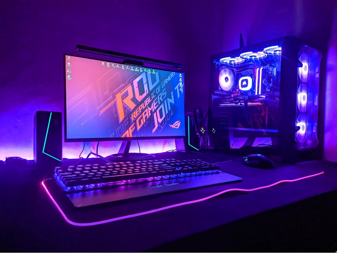 Gaming computer setup with monitor, keyboard and tower in purple RGB light